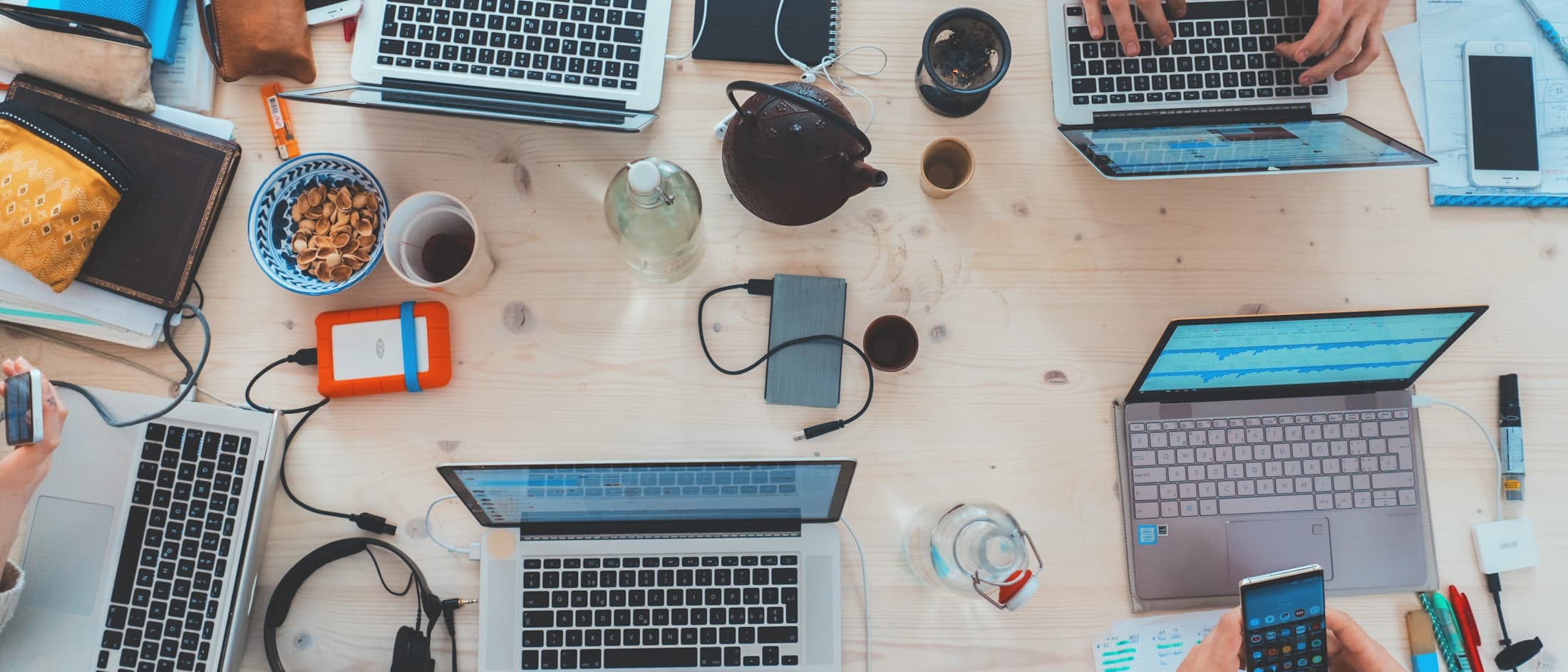 Software team working together across laptops at a shared desk